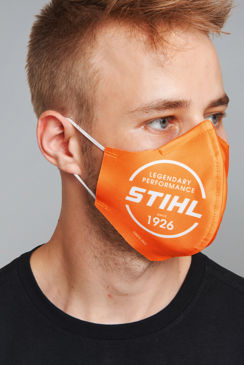 Un homme porte un masque facial STIHL orange.