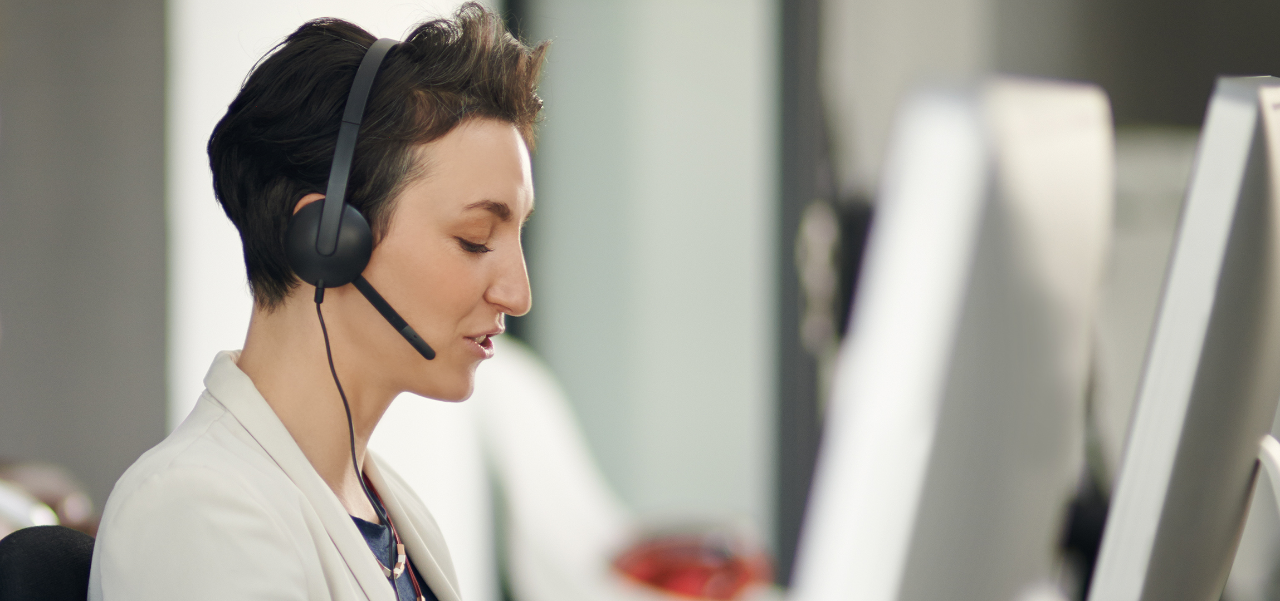 En premier plan un homme portant un casque et parlant dans un microphone