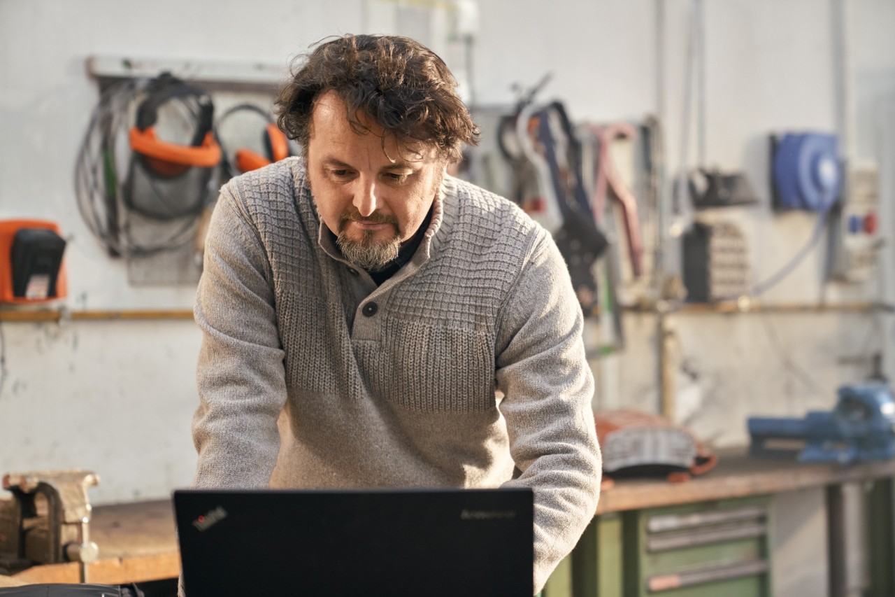 Un revendeur dans son magasin tenant une tronçonneuse MS 261 C posée sur une table