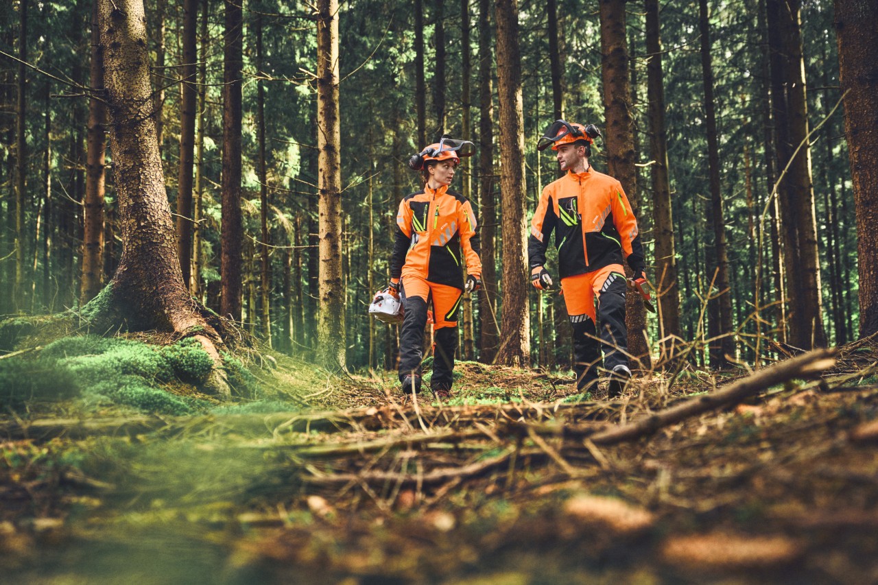 Deux personnes dans le bois avec un équipement de sécurité STIHL