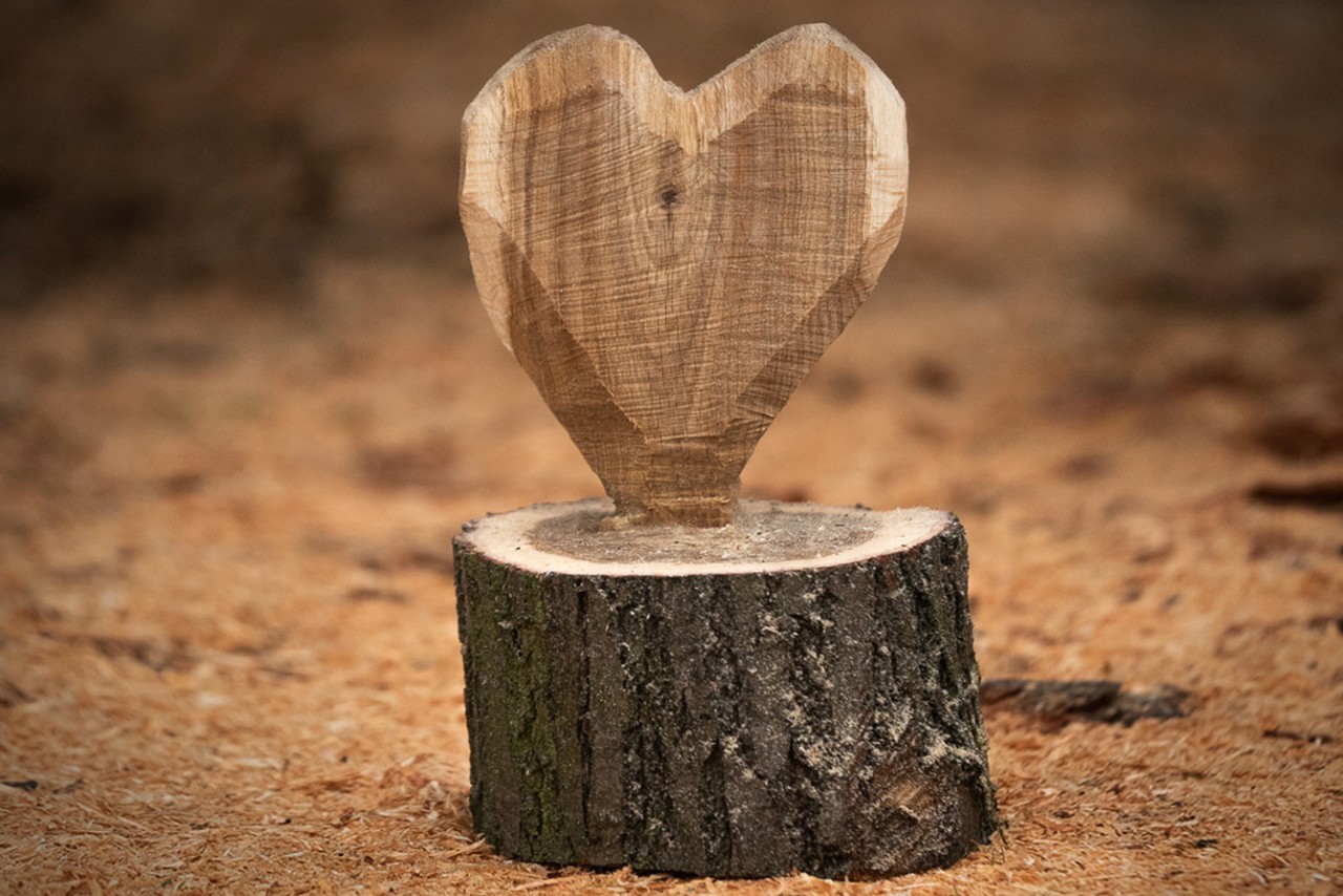 Le cœur en bois à faire soi-même se trouve sur le sol entre les copeaux