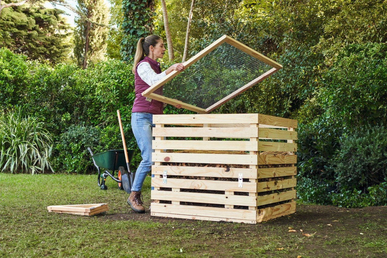 Femme qui couvre un composteur DIY