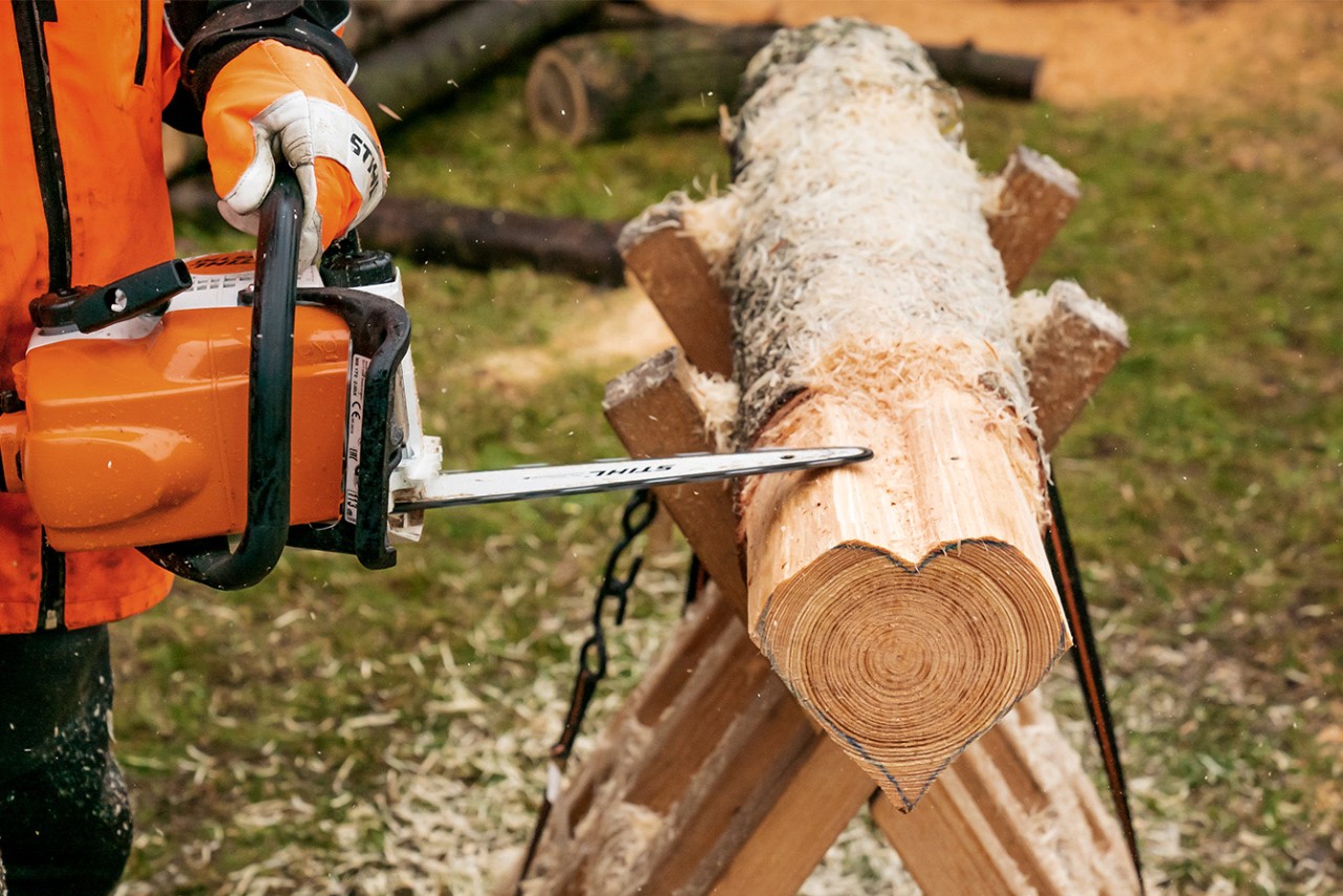 Sculpter une série de cœurs dans une même bûche : lissage des bords du cœur avec une tronçonneuse thermique STIHL MS 170