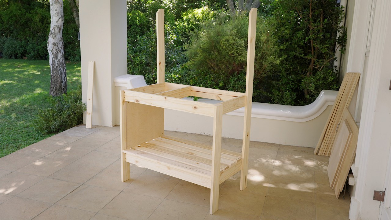 Table de jardinage avec la paroi latérale gauche qui vient d’être fixée