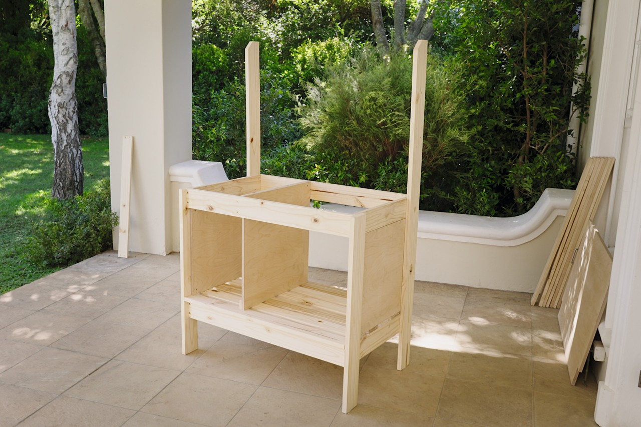 Table de jardinage avec une troisième paroi latérale qui vient d’être vissée