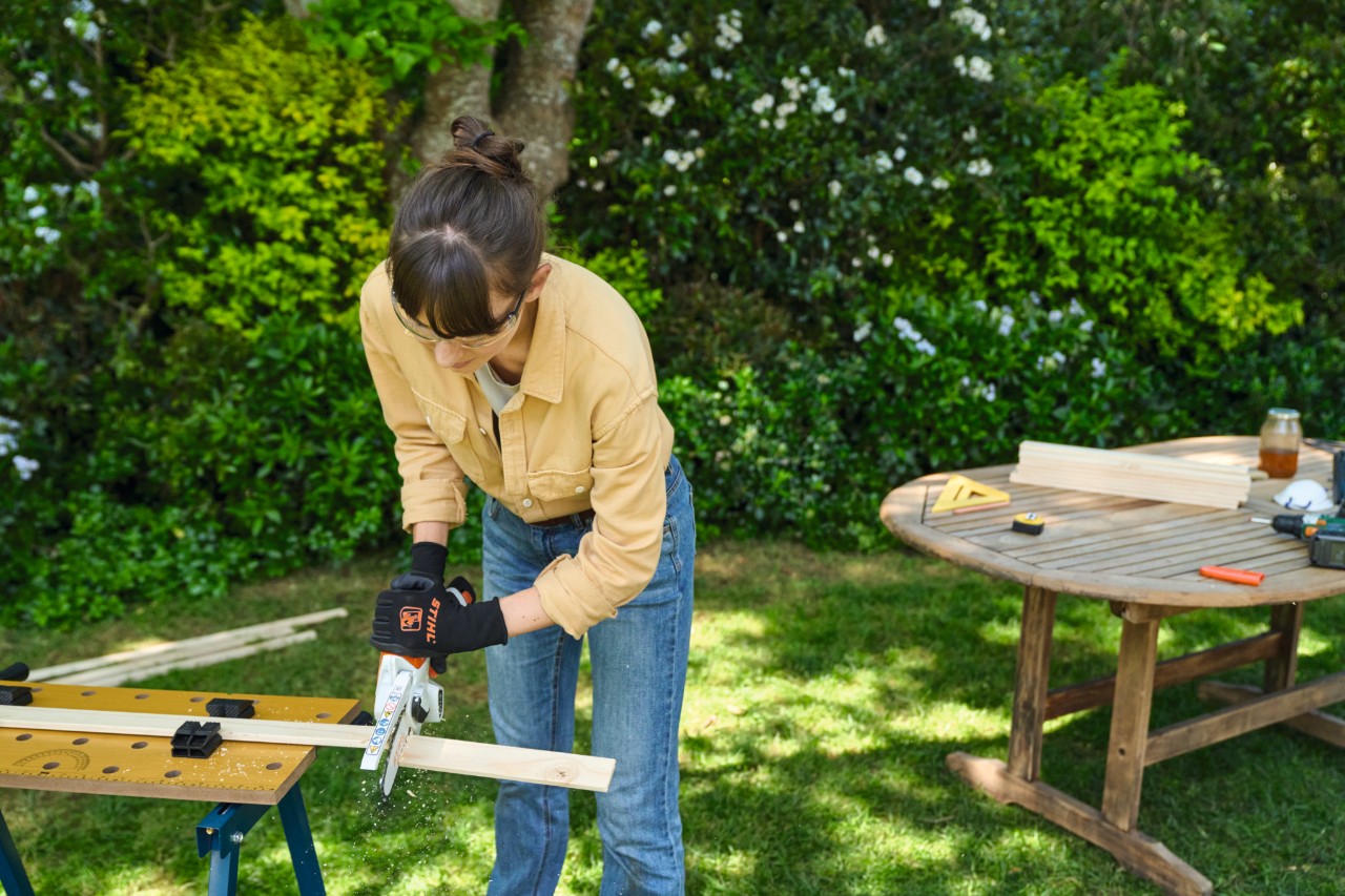 Femme sciant une latte avec la scie de jardin STIHL GTA 26