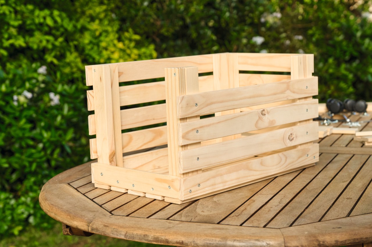 Les lattes sont fixées de chaque côté de la jardinière en bois