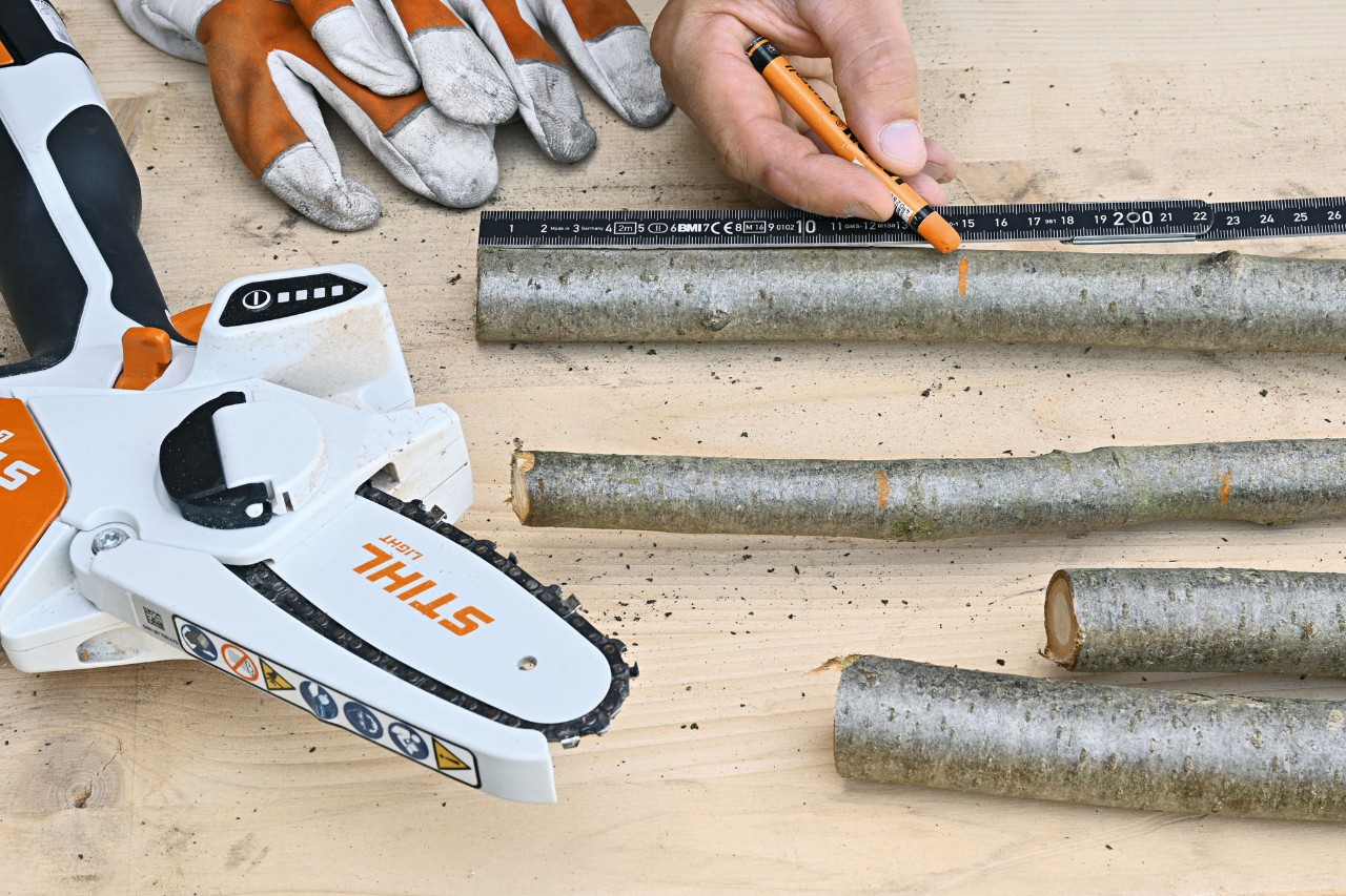 Longueurs appropriées marquées sur les branches, gants de protection et  scie de jardin à batterie STIHL GTA 26 