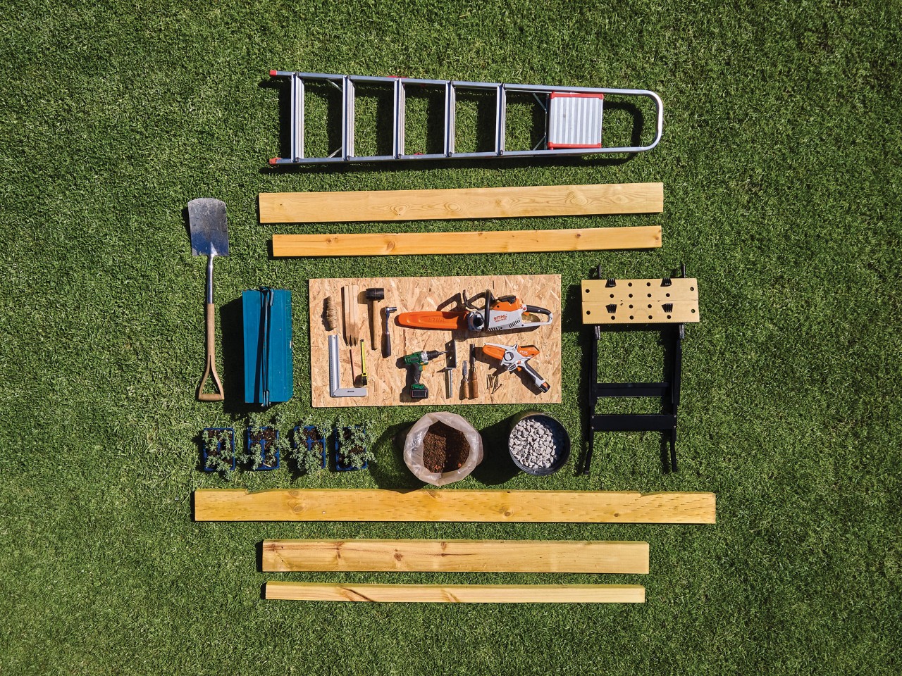 Comment construire un abri de jardin : matériaux et outils disposés proprement sur une pelouse verte