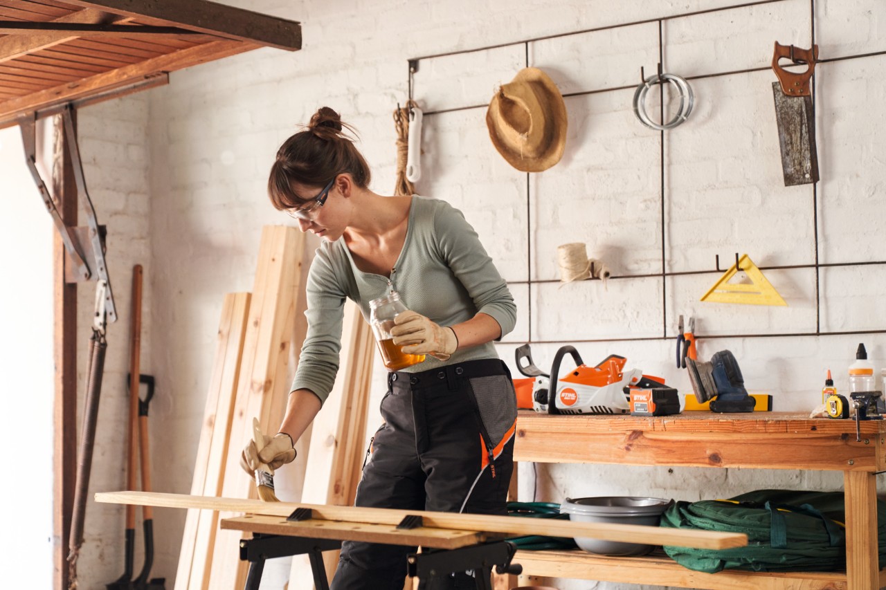 Demme huilant une latte de bois dans un atelier