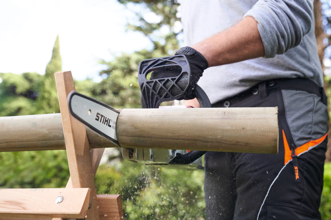 Homme sciant une branche avec une tronçonneuse à batterie STIHL