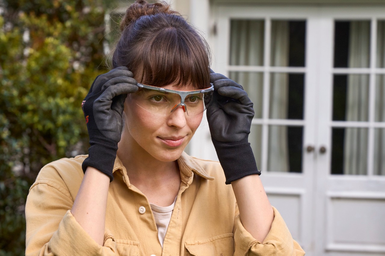 Une femme met ses lunettes de protection