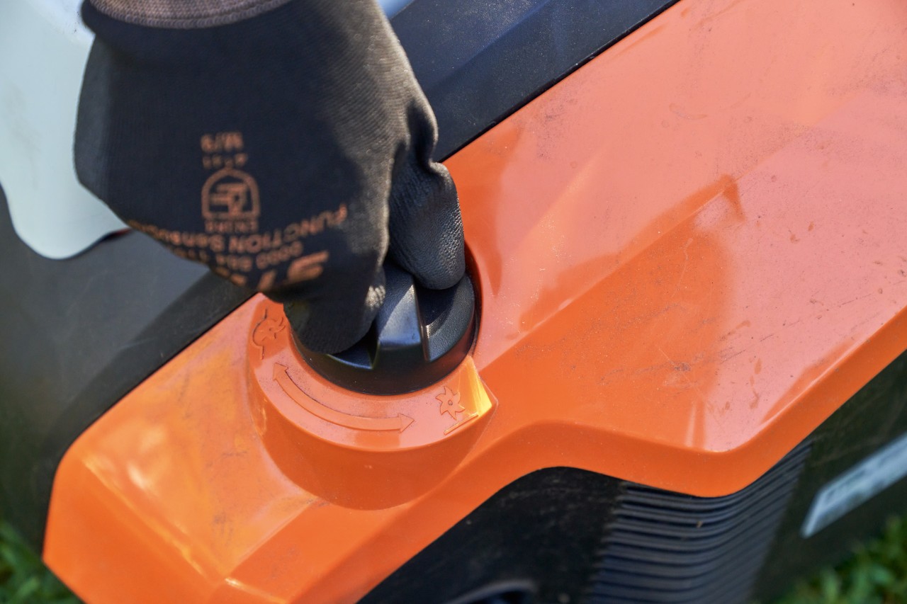 Main avec gant STIHL FUNCTION SENSOTOUCH tourne la poignée rotative de l’aérateur de pelouse sans fil STIHL RLA 240.