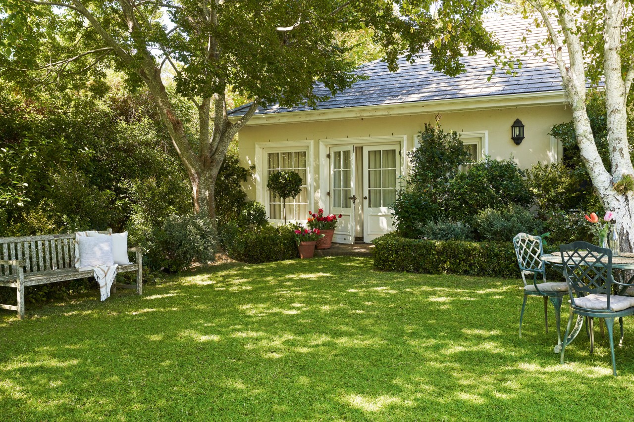 un jardin avec une pelouse verte et saine après le chaulage avec la maison en arrière-plan