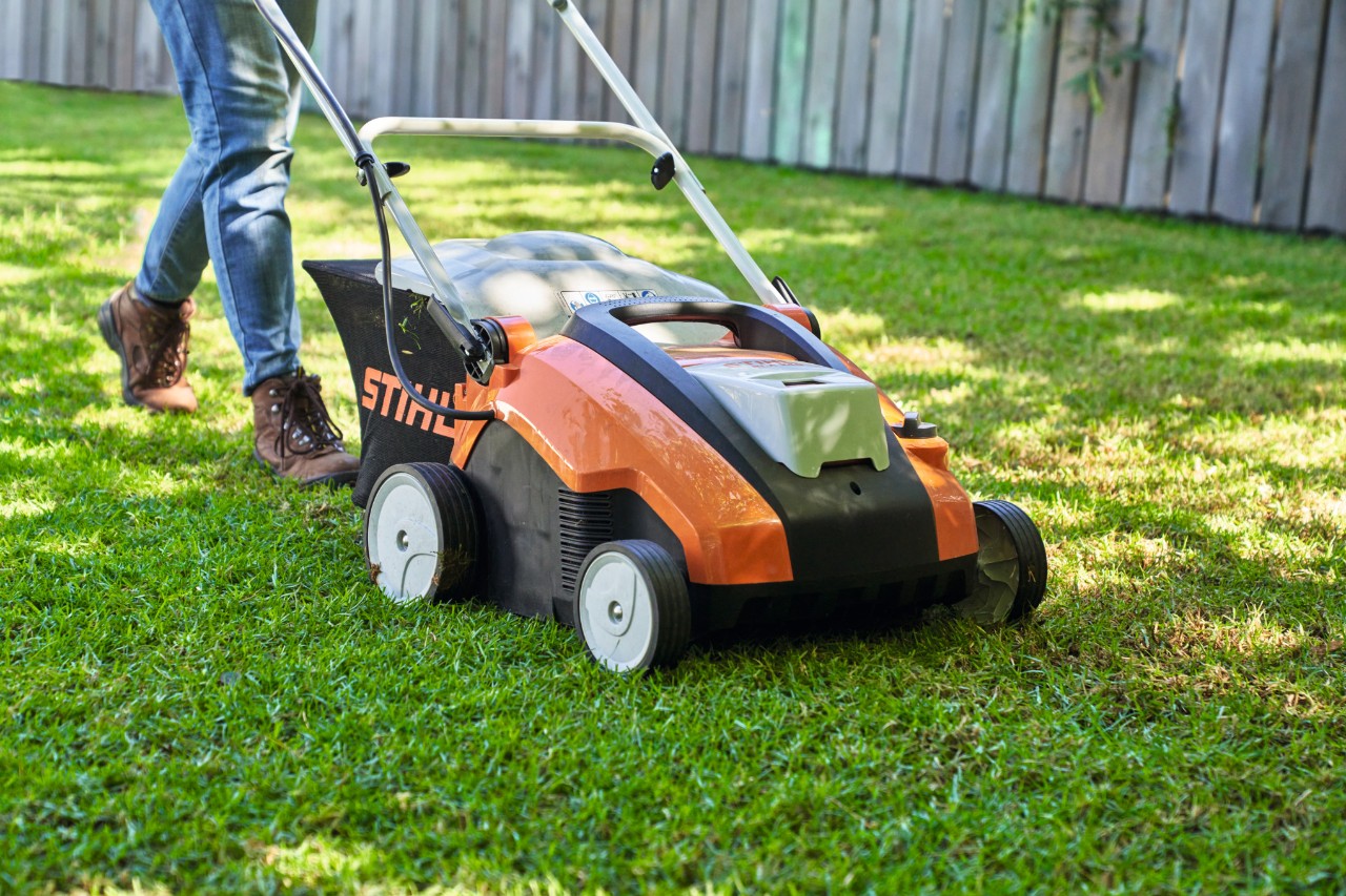 Gros plan sur une personne scarifiant un gazon d’ombre