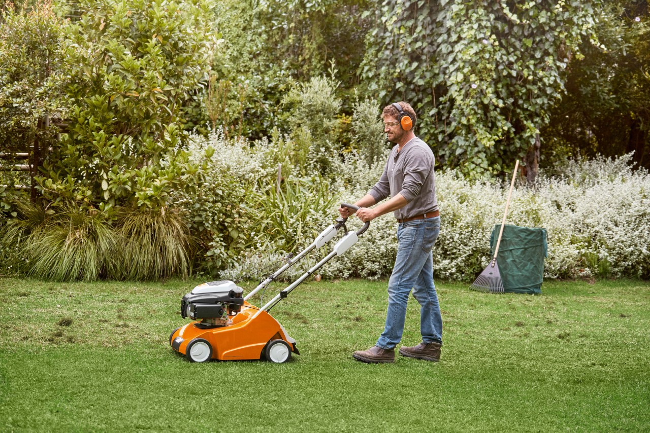 Un homme scarifie sa pelouse avec un scarificateur RL 540 STIHL