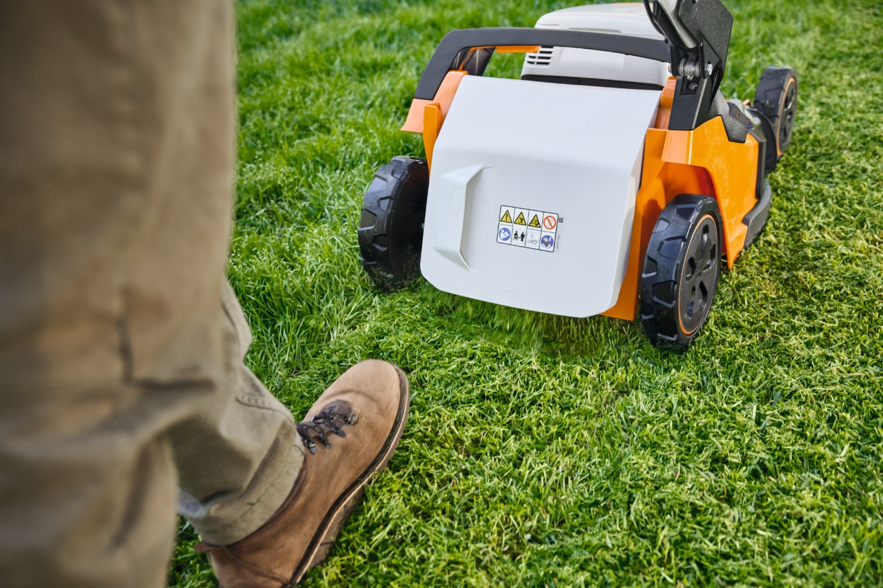 homme pratique du mulching avec une tondeuse sur batterie