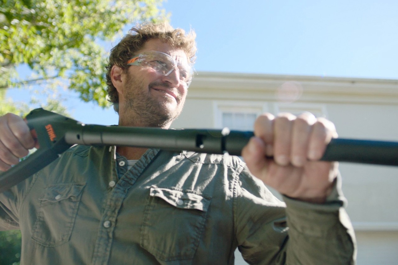 Homme portant des lunettes de protection tenant le nettoyeur haute pression STIHL RE 130 PLUS pour réaliser un sablage humide