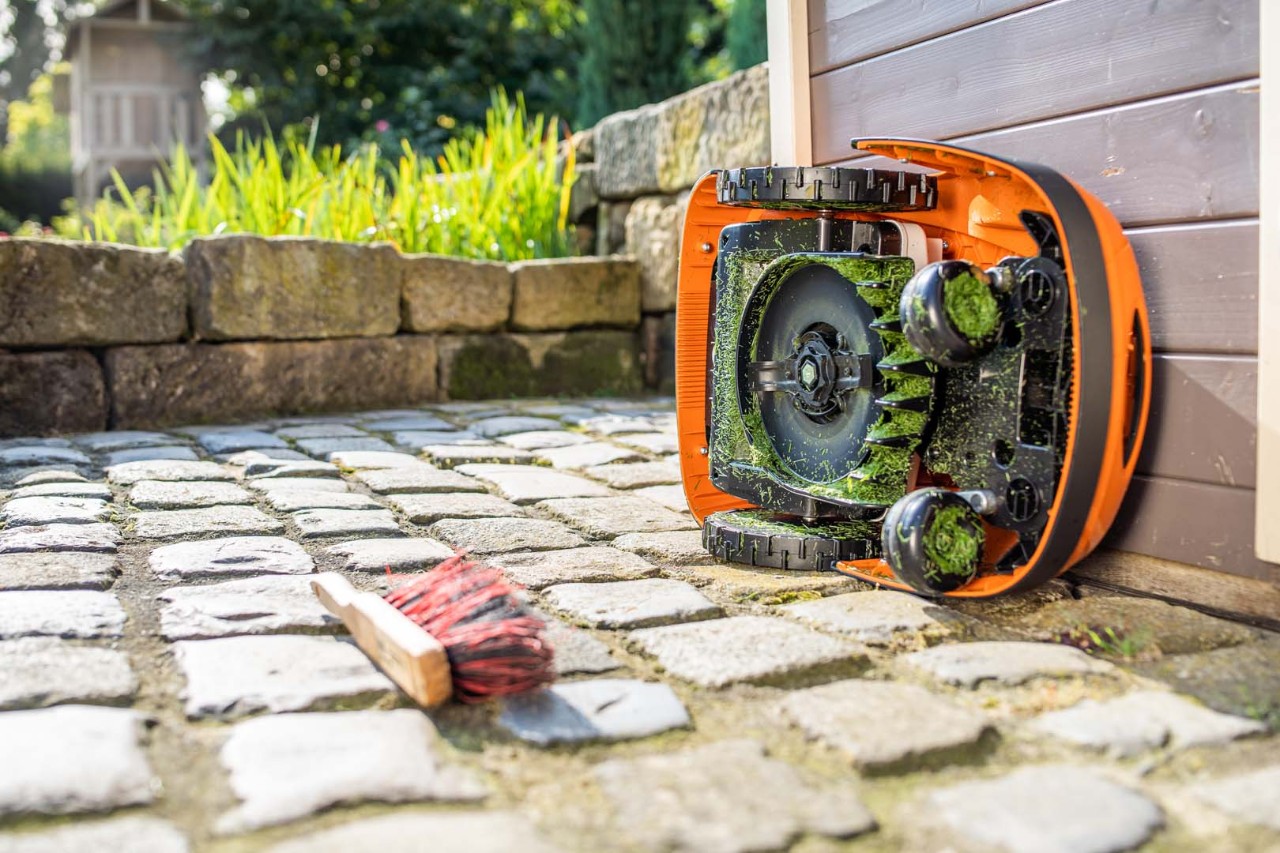 Robot de tonte STIHL iMOW® basculé sur le côté et prêt pour le nettoyage