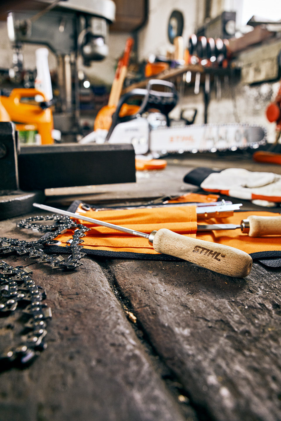 Lime et chaîne de tronçonneuse STIHL, autres outils permettant l’entretien et l’affutage de chaines à l’arrière-plan