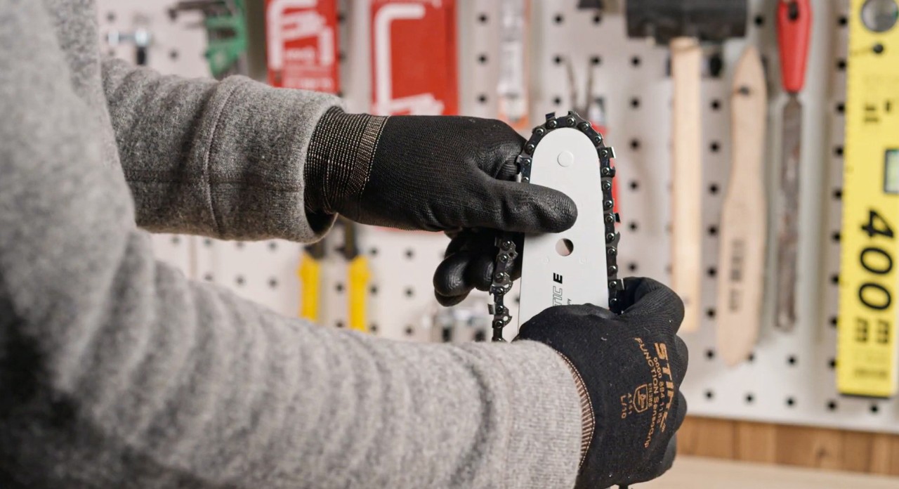 Installation d’une chaîne sur le guide-chaîne d’une tronçonneuse STIHL MS 180