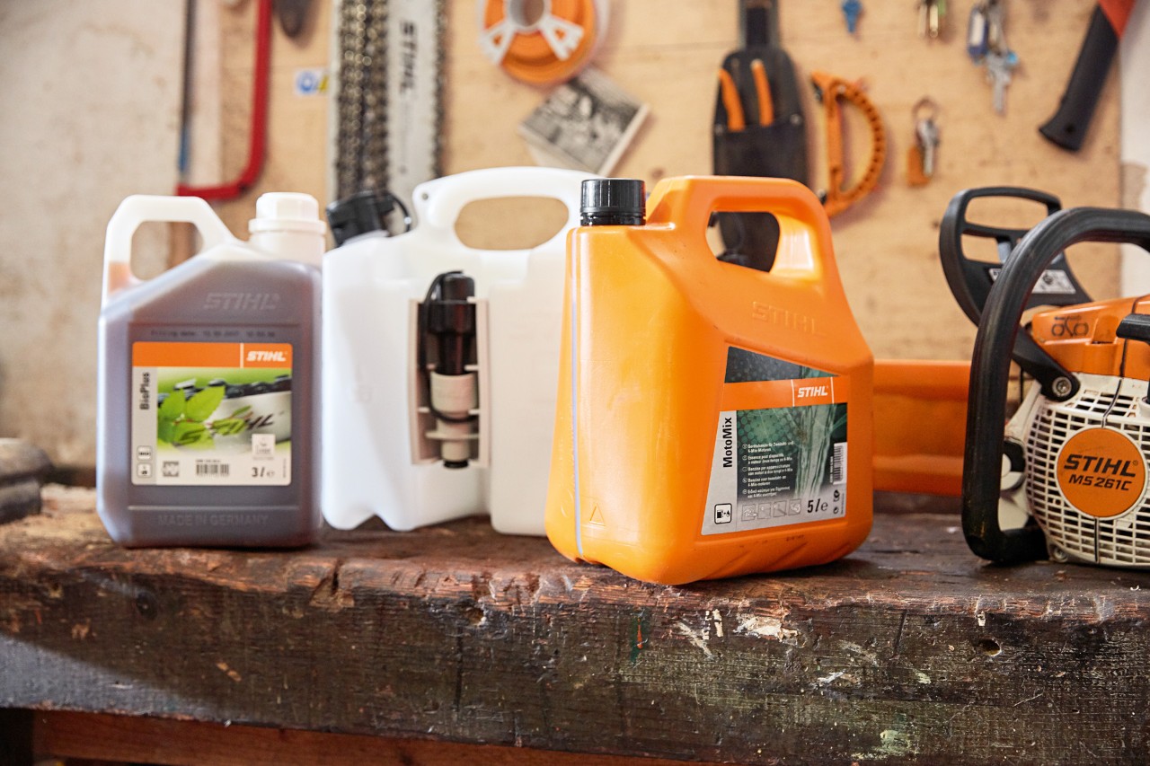 Un bidon de mélange MotoMix STIHL et une tronçonneuse MS 261 C dans un atelier. 