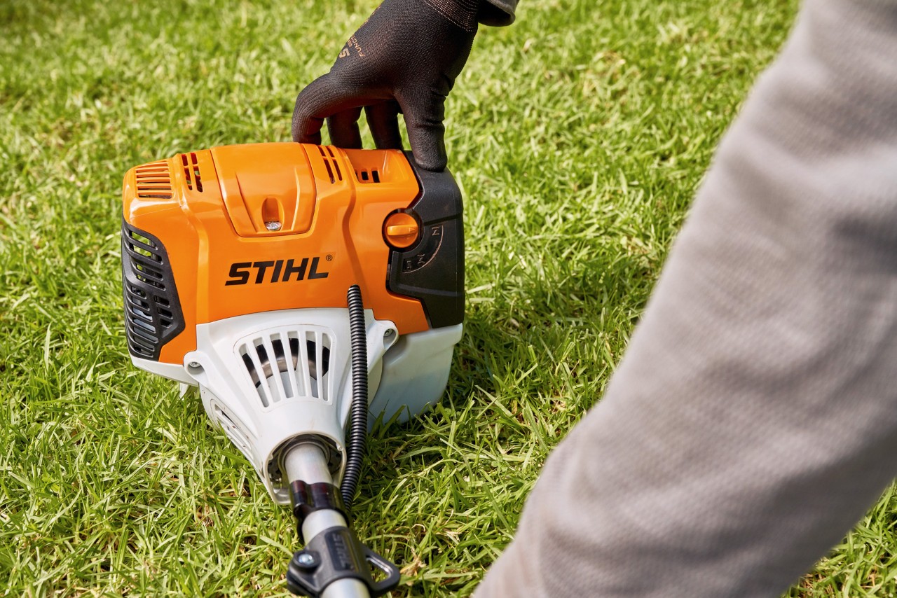 Un homme maintenant fermement la débroussailleuse à essence STIHL&nbsp;FS&nbsp;91 au sol