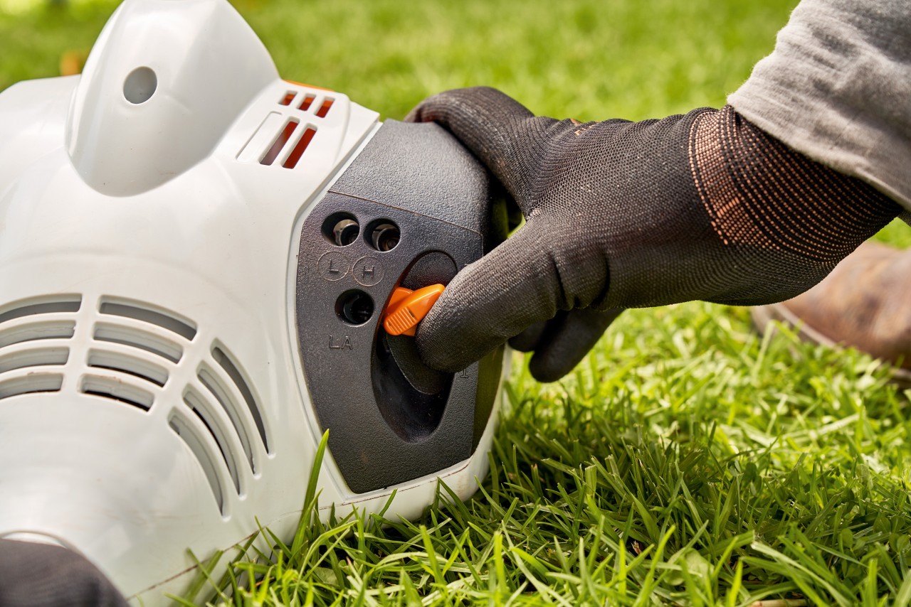 Un homme réglant le levier de la débroussailleuse à essence STIHL&nbsp;FS&nbsp;56 pour la démarrer