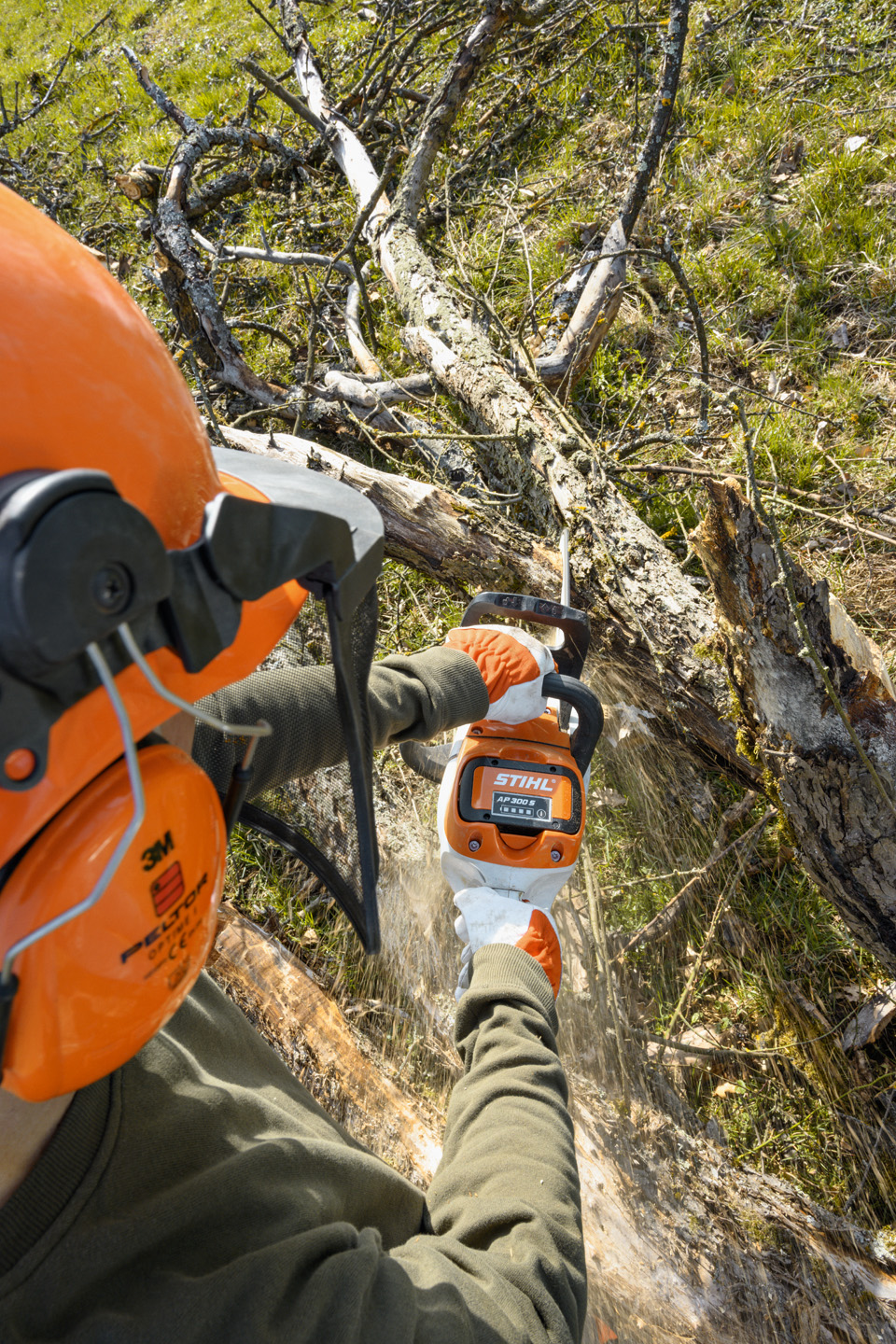 Une tronçonneuse à batterie STIHL MSA 220 C-B utilisée pour ébrancher un tronc d’arbre