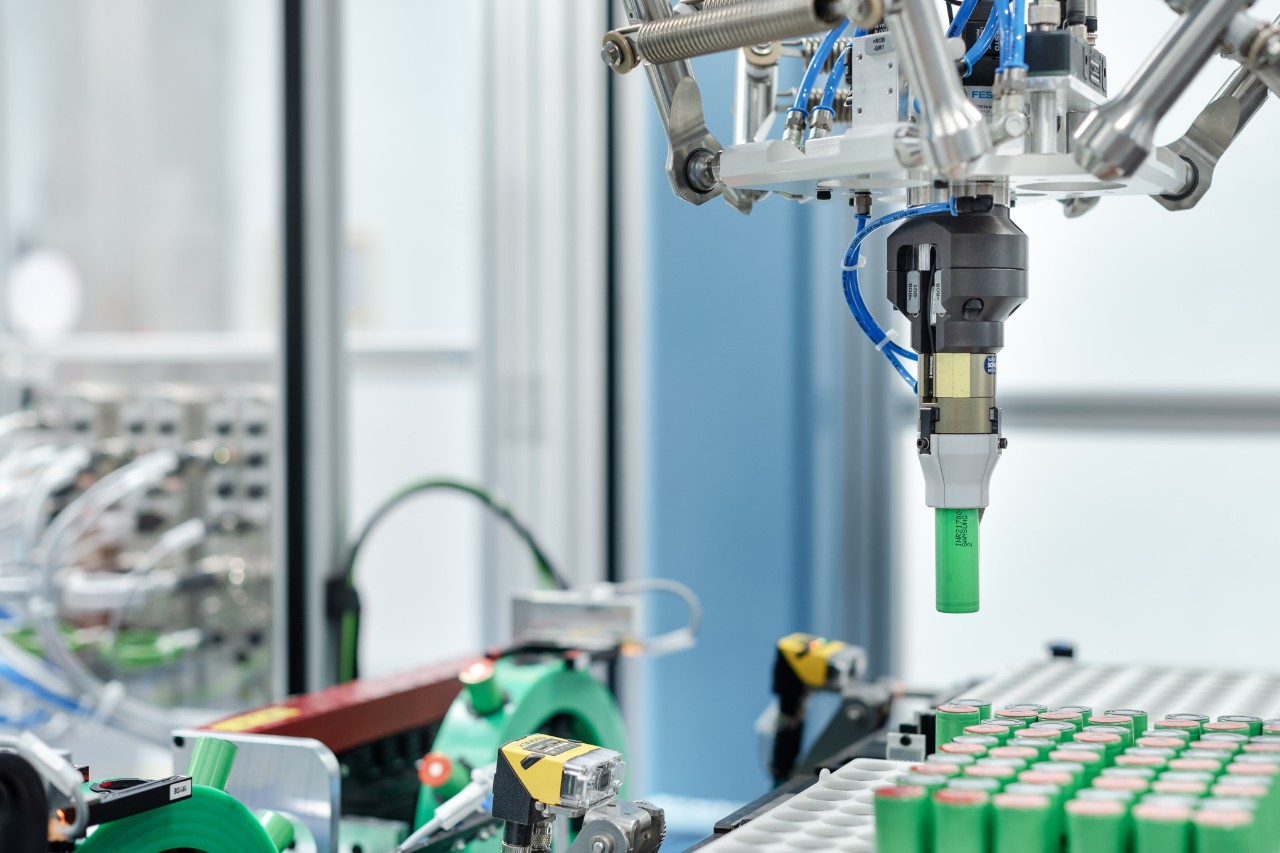 Un robot pick and place insère les cellules de batterie dans les porte-cellules