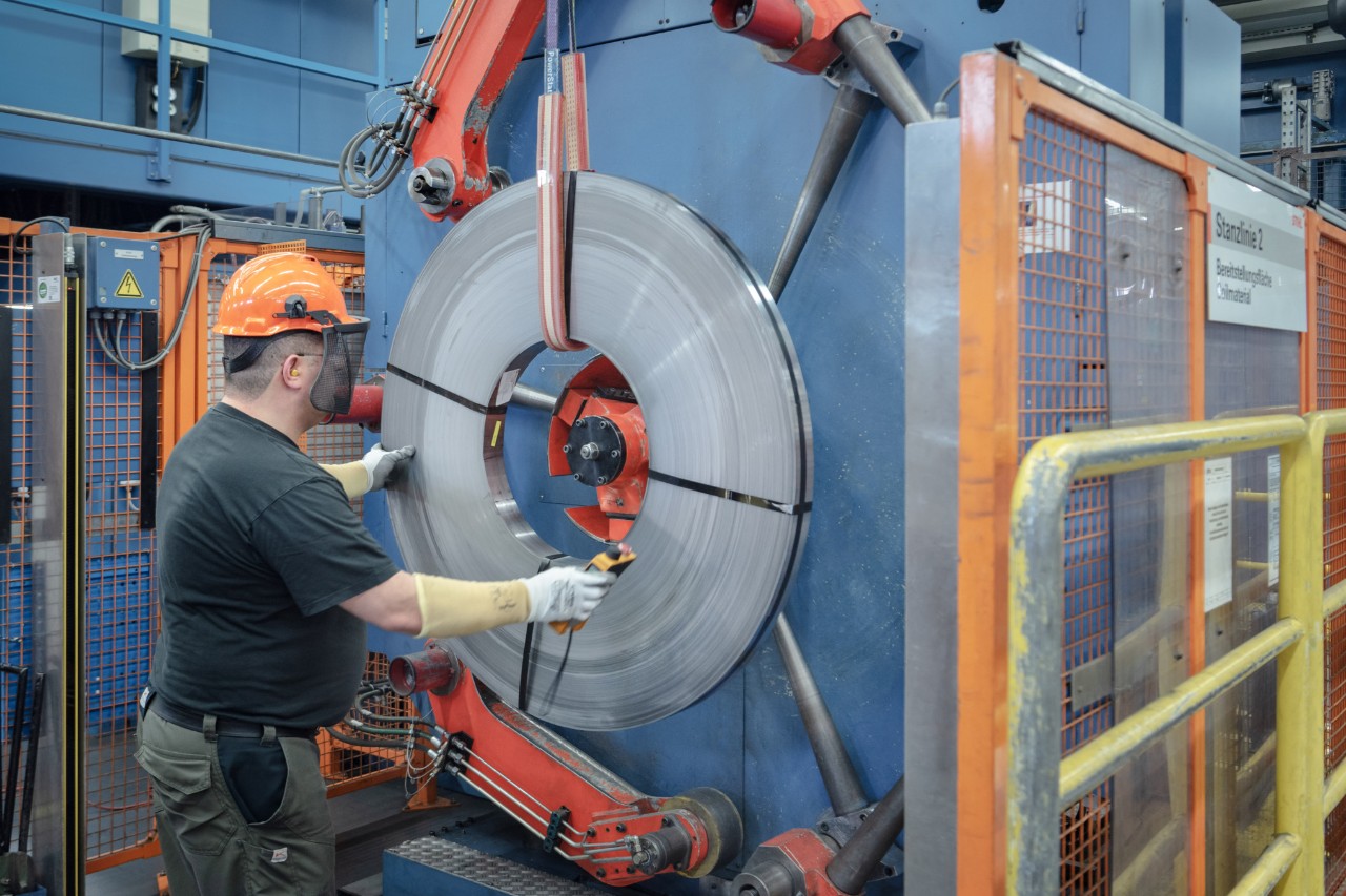 Un homme en équipement de protection travaille sur une machine pour la fabrication de chaînes chez STIHL 