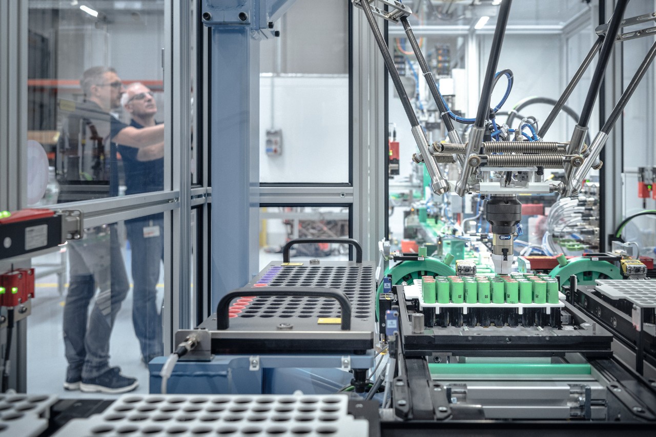 Deux hommes dans la fabrication de batteries STIHL entourés de machines et de robots