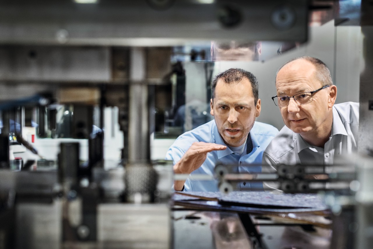 Deux hommes regardent une installation dans l’usine de chaînes