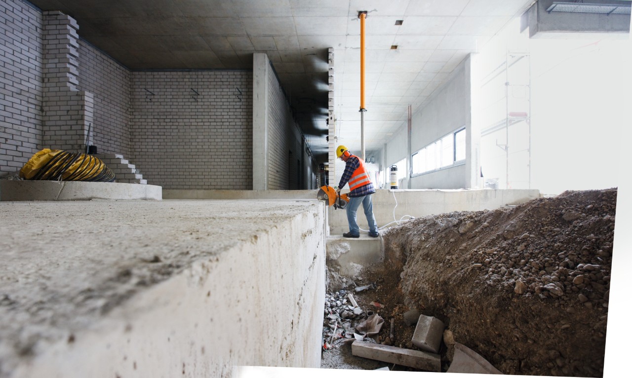 Homme avec une découpeuse à disque à essence STIHL TS 500i découpant un boulon en acier sur un chantier