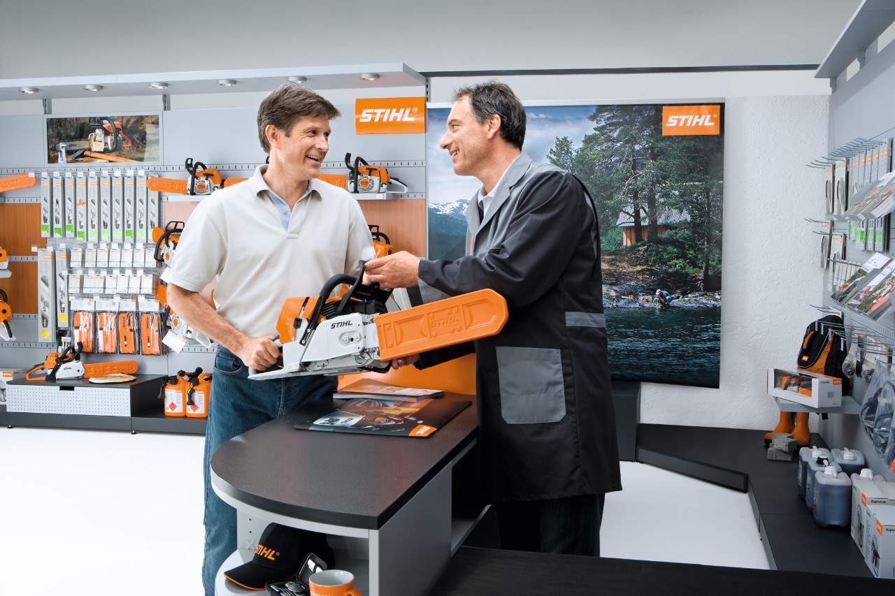 Un revendeur STIHL présente une tronçonneuse à un client