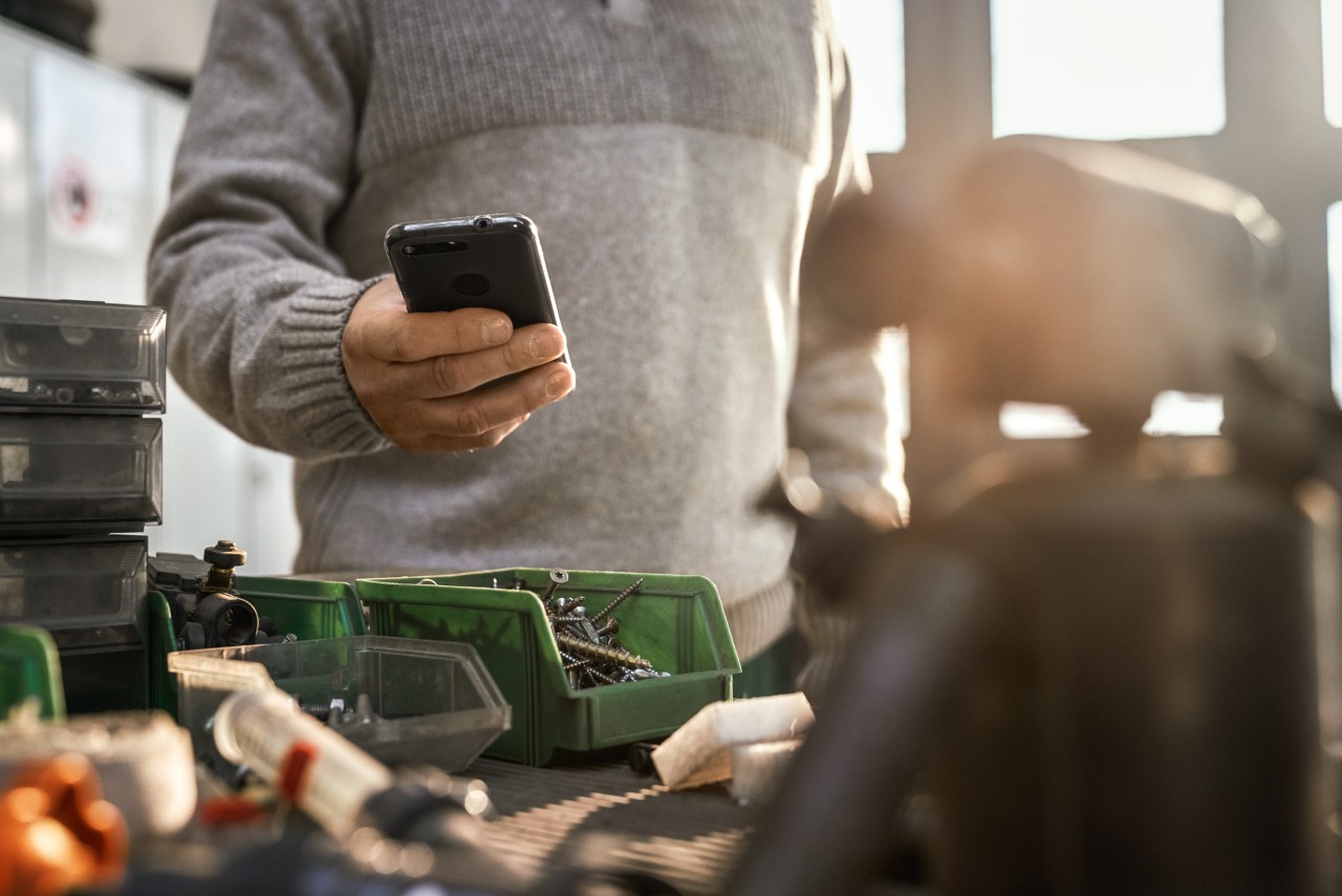 Une personne utilisant son smartphone dans un atelier