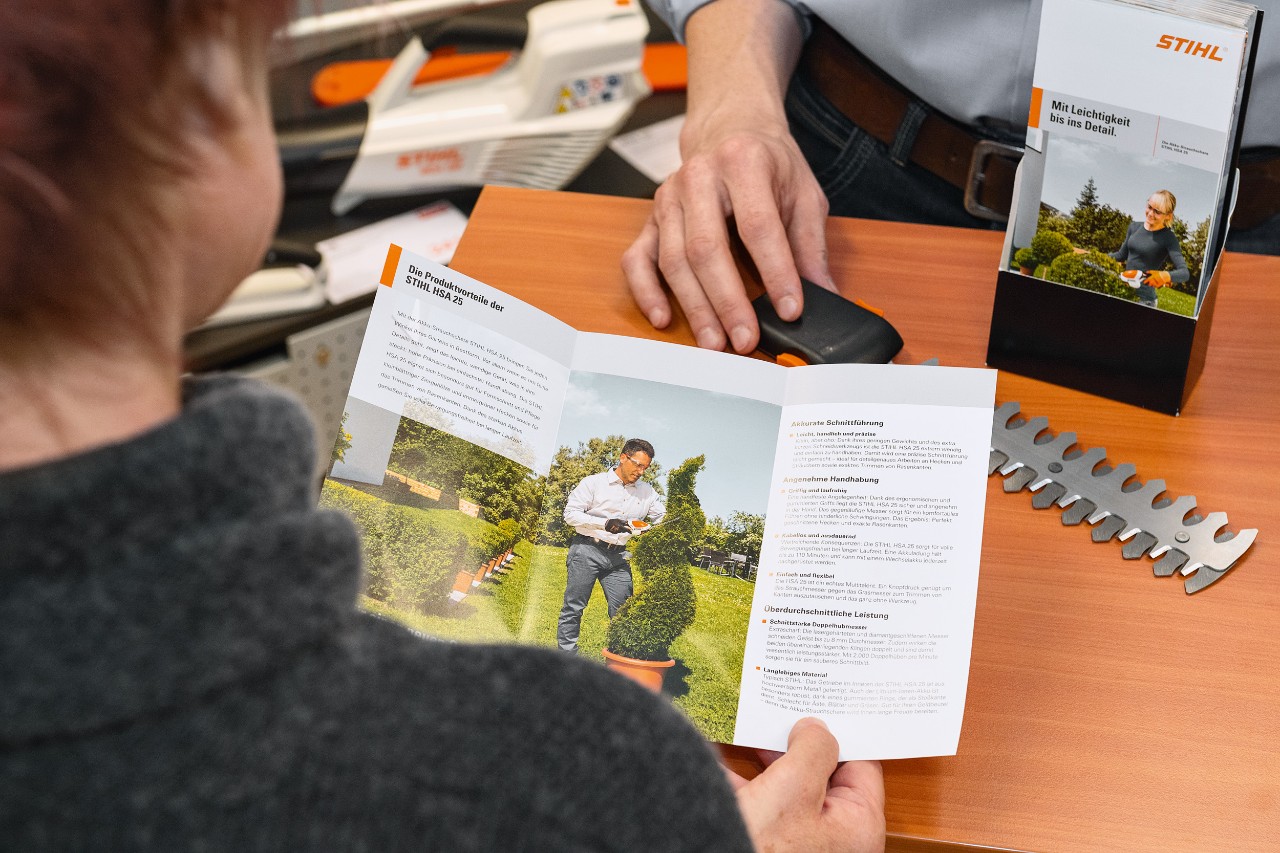 Une personne découvre les avantages du modèle STIHL HSA&nbsp;25 dans une brochure