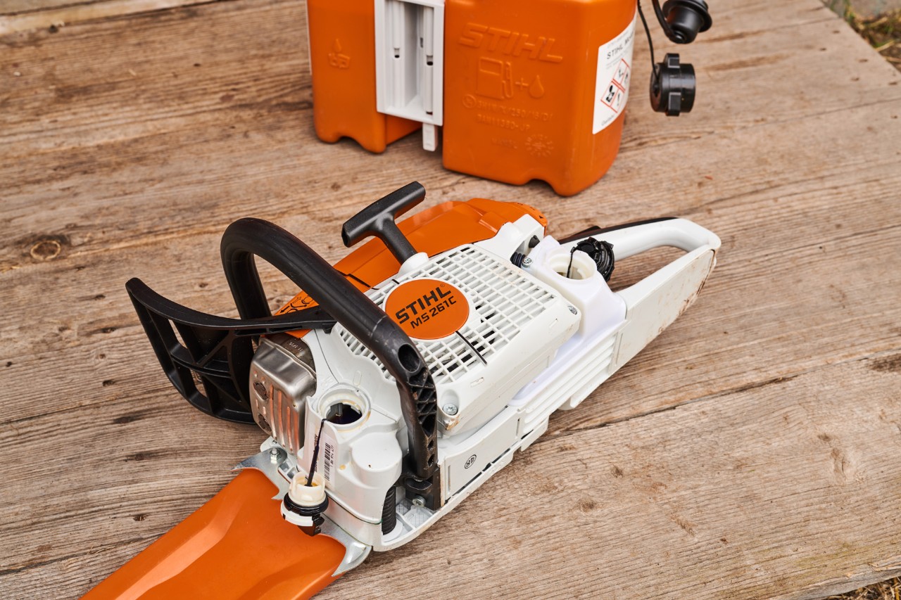 Tronçonneuse thermique STIHL MS 261  sur le sol. Les bouchons des réservoirs d’huile et de carburant ont été retires